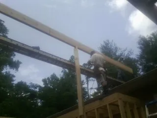 Carpenter setting a ridge beam over a new addition frame — Ice Dam Removal by Roofing Brothers in Hiwassee