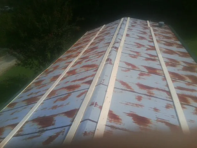 Rusted metal roof panels with new wood purlins before replacement — Storm Damage Roof Repair in Hiwassee by Roofing Brothers