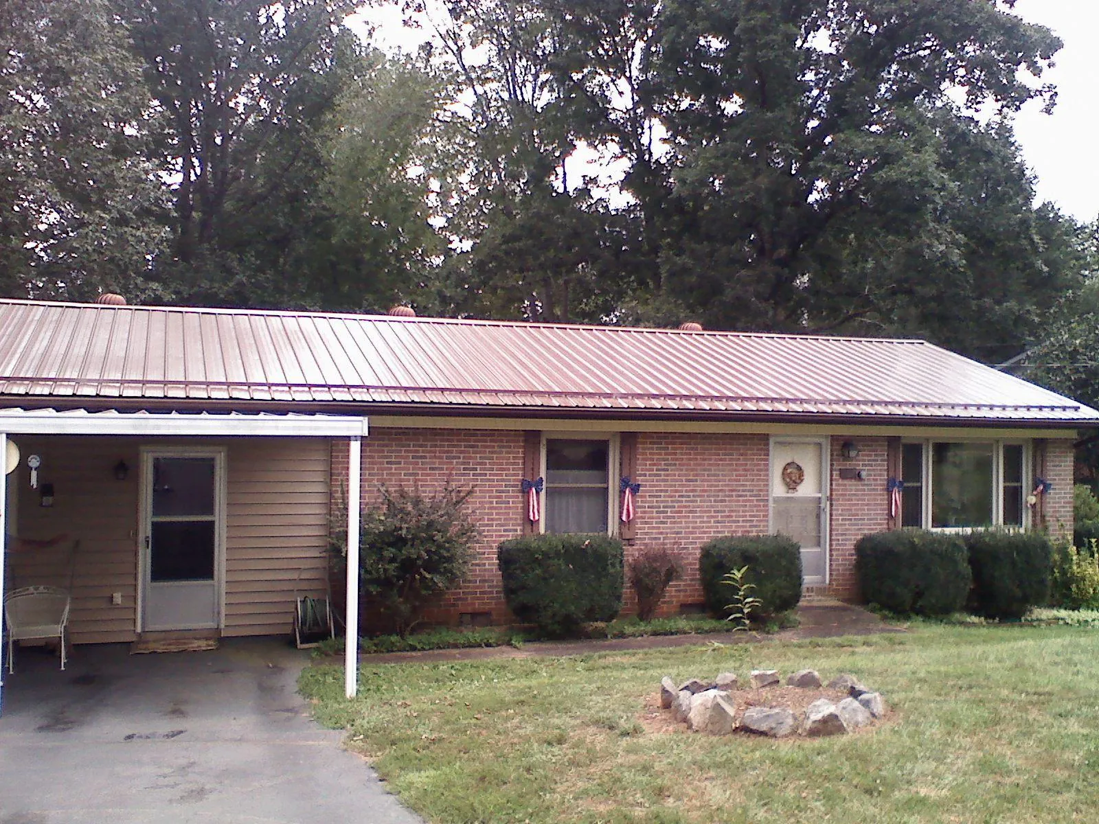 Bronze metal roof and carport on a brick ranch home — Roof Repair work by our crew in Hiwassee